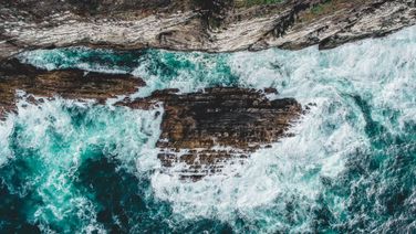 Drone Photography of water crashing on Cliffs 