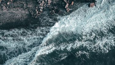 Drone photograph of waves crashing on a cliff